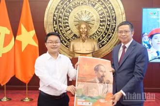 Đại diện Cơ quan thường trú Báo Nhân Dân tại Trung Quốc trao tặng phụ san đặc biệt tới Đại sứ Phạm Thanh Bình.
