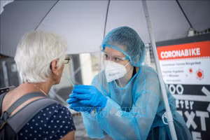Nhân viên y tế lấy mẫu xét nghiệm COVID-19 cho người dân tại Berlin, Đức, ngày 30/7/2021. Ảnh: AFP/TTXVN