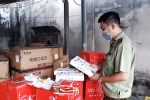 Cán bộ quản lý thị trường kiểm tra chất lượng sản phẩm bánh, kẹo nhập khẩu. (Ảnh: NGUYÊN TRANG)