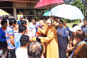 Thượng tọa Thích Minh Quang tặng quần áo, đồ dùng cho người dân Lào.