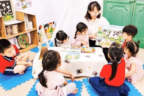 Cô và trò làm quen với sách trước năm học thí điểm Chương trình giáo dục mầm non mới. (Ảnh: THU TRANG)