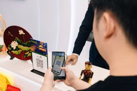Khách hàng trải nghiệm thanh toán QR xuyên biên giới. (Ảnh: HOÀNG TRANG)