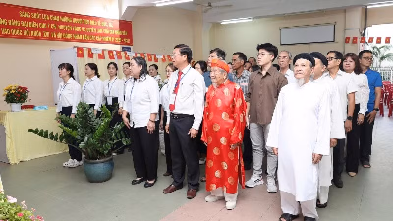 Nhà nghiên cứu Nguyễn Đình Tư (106 tuổi) mặc áo dài đỏ tham gia bầu cử sáng 15/3.