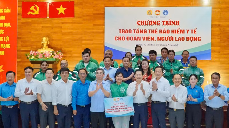 Lãnh đạo thành phố cùng các đại biểu trao thẻ Bảo hiểm y tế cho đoàn viên, người lao động. 