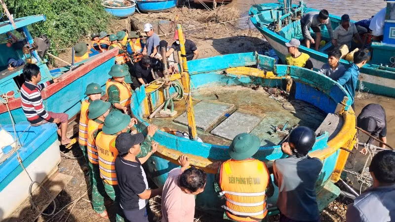 Bộ đội biên phòng hỗ trợ ngư dân kéo tàu lên.