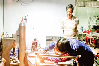 Ông Nguyễn Văn Kiệt quan sát thợ hàn thực hiện công đoạn hoàn thiện sản phẩm.