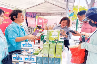 Người dân mua sắm tại các gian hàng trong hội chợ. (Ảnh XUÂN TRƯỜNG)