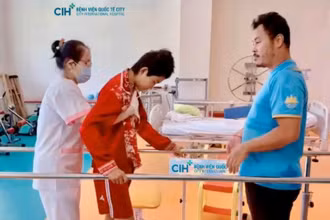 Bệnh nhi Toun Sreynich tập hồi phục với sự hỗ trợ của bác sĩ. 