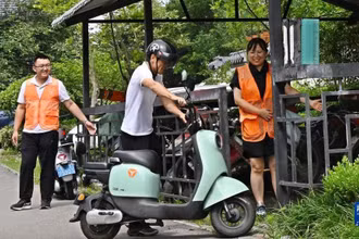 Nhân viên hướng dẫn người dân đưa xe điện vào điểm sạc pin tập trung ở thành phố Giao Châu, Thanh Đảo, tỉnh Sơn Đông, Trung Quốc. (Ảnh: Tân Hoa xã)