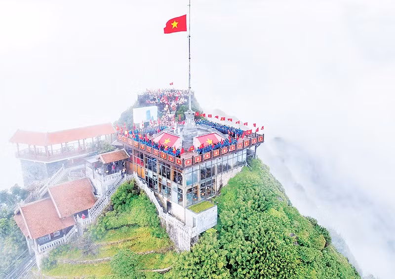 Đoàn viên, thanh niên cùng thực hiện nghi thức chào cờ, hát Quốc ca trên đỉnh núi cao nhất nằm ở trung tâm dãy Hoàng Liên Sơn. 