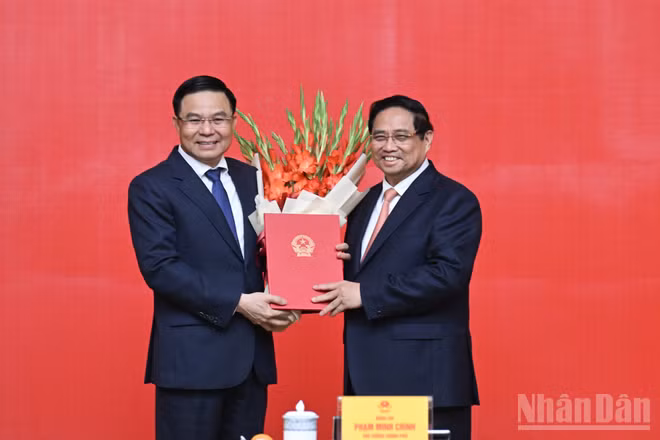 Thủ tướng Phạm Minh Chính trao Quyết định bổ nhiệm và tặng hoa chúc mừng đồng chí Lê Mạnh Hùng.