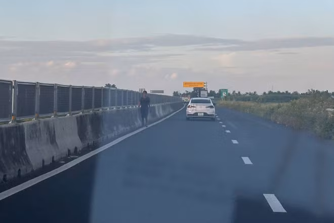 Người đi bộ băng qua làn đường cao tốc Lộ Tẻ-Rạch Sỏi tiềm ẩn nguy cơ tai nạn giao thông. ( Ảnh: Thanh Dũng)