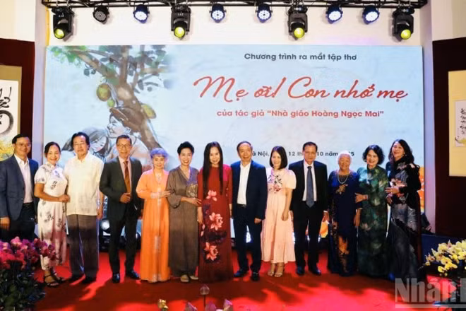 Tác giả tập thơ, nhà giáo Hoàng Thị Ngọc Mai (áo dài đỏ) cùng các đại biểu dự sự kiện.