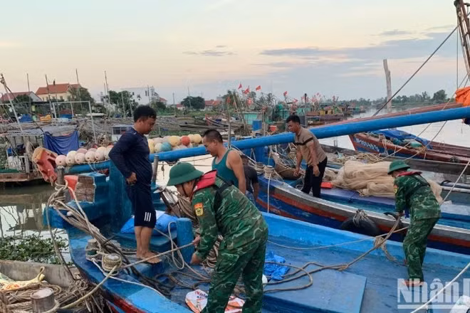 Cán bộ, chiến sĩ Đồn Biên phòng Đoàn Xá hỗ trợ ngư dân chằng buộc phương tiện phòng, chống bão Ragasa.