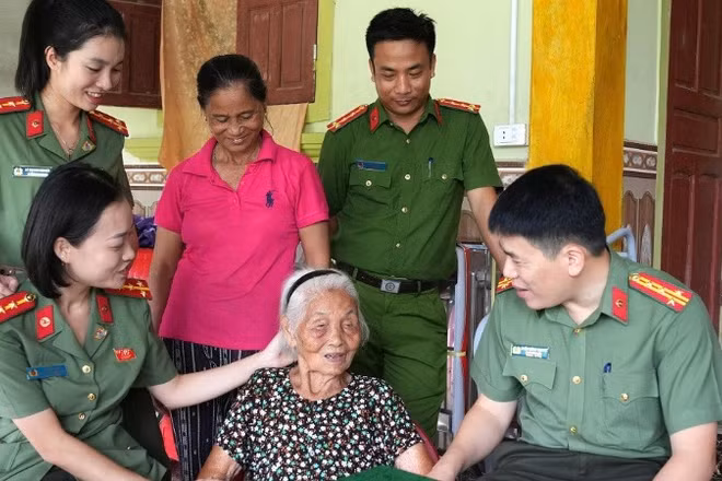 Đại tá Trần Hồng Quang, Phó Giám đốc Công an tỉnh Nghệ An ân cần thăm hỏi sức khỏe Mẹ Việt Nam Anh hùng Nguyễn Thị Năm. (Ảnh: CÔNG AN NGHỆ AN)