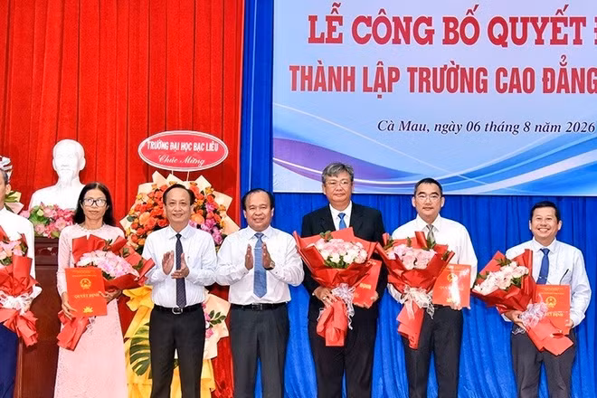 Phó Bí thư Tỉnh ủy, Chủ tịch Hội đồng nhân dân tỉnh Phạm Văn Thiều (bên trái) và Phó Chủ tịch Ủy ban nhân dân tỉnh Nguyễn Minh Luân trao quyết định, tặng hoa chúc mừng các đồng chí được bổ nhiệm giữ chức Hiệu trưởng, Phó Hiệu trưởng Trường cao đẳng Cà Mau. (Ảnh: CTV)