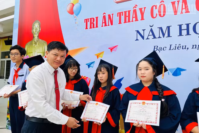 Thầy giáo Phan Thành Trung, Bí thư Chi bộ, Hiệu trưởng Trường Trung học cơ sở Lê Thị Cẩm Lệ, phường Bạc Liêu (Cà Mau), tặng giấy khen cho các em học sinh có thành tích học tập xuất sắc. (Ảnh: TRỌNG DUY)