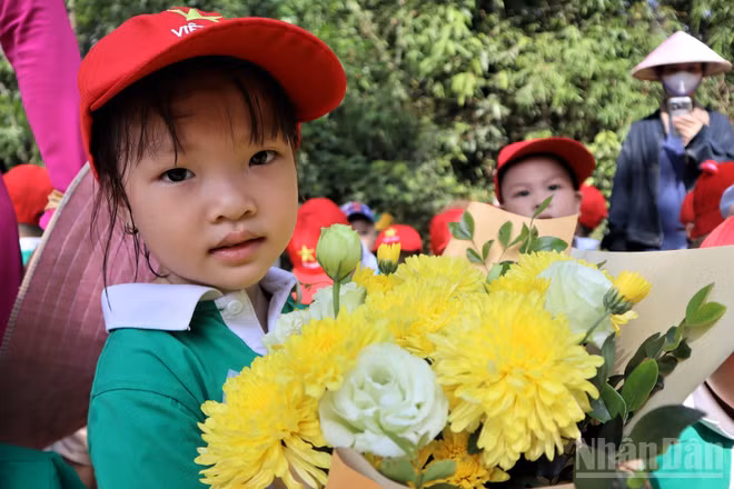 Các em nhỏ với những bó hoa tươi thắm dâng lên Bác Hồ kính yêu.