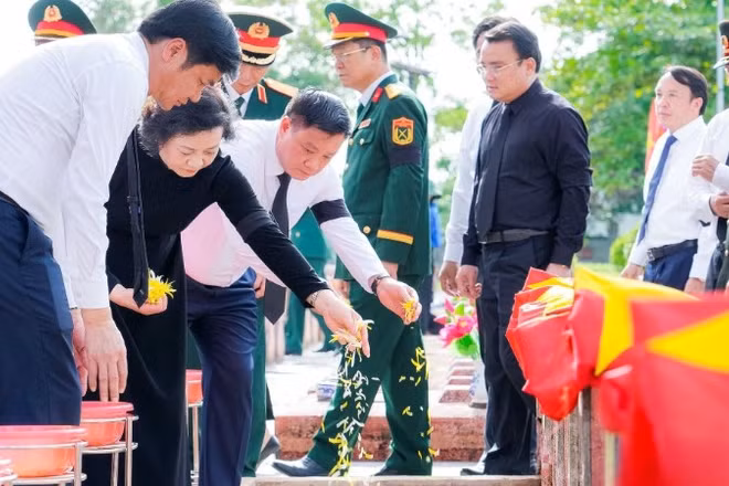 Các đại biểu thực hiện nghi lễ rải hoa ở các phần mộ liệt sĩ.