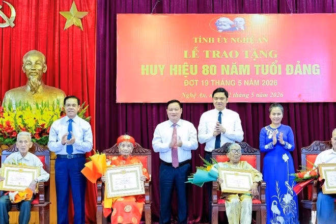 Các đồng chí trong Thường trực Tỉnh ủy Nghệ An trao Huy hiệu 80 năm tuổi Đảng và tặng hoa chúc mừng các đảng viên. (Ảnh: PHẠM BẰNG)