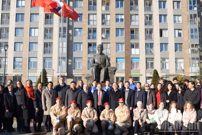 Đại biểu hai nước dâng hoa tại Tượng đài Chủ tịch Hồ Chí Minh tại Saint Petersburg. (Ảnh: THANH THỂ)