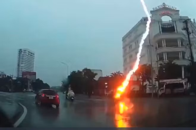 Tia sét đánh trúng người điều khiển xe máy đang lưu thông trên đường. (Ảnh cắt từ clip)