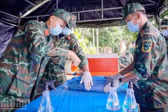Đội lấy mẫu cẩn thận lấy mẫu hài cốt liệt sĩ chưa xác định được thông tin để phục vụ giám định ADN tại nghĩa trang liệt sĩ tỉnh An Giang, ở phường Rạch Giá.