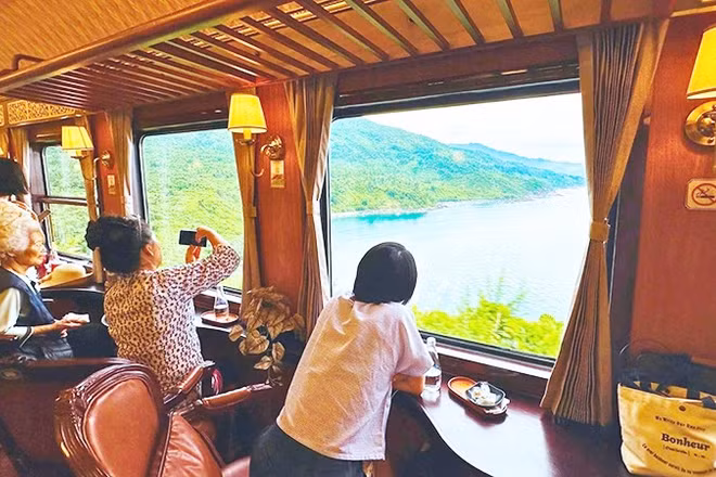 Du khách hào hứng chụp ảnh phong cảnh trên chuyến tàu “Kết nối di sản miền Trung”.