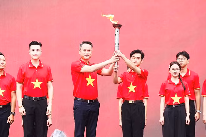 Chủ tịch T.Ư Hội LHTN Việt Nam Nguyễn Kim Quy trao ngọn đuốc "Tôi yêu Tổ quốc tôi" cho đại diện thanh niên cả nước. Ảnh: TUẤN MINH