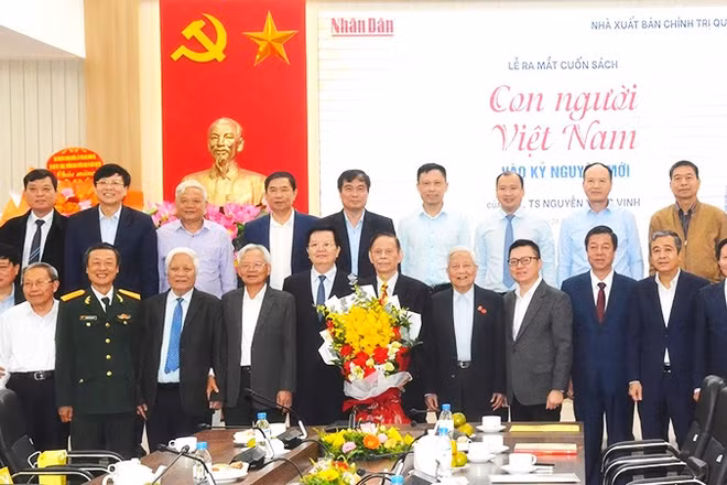 PGS, TS Nguyễn Hồng Vinh (cầm hoa) cùng các đại biểu, đồng nghiệp chụp ảnh lưu niệm trong lễ ra mắt sách.