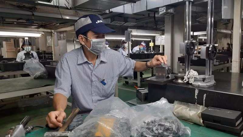 Công nhân Công ty trách nhiệm hữu hạn Juki Việt Nam, Khu Chế xuất Tân Thuận, Thành phố Hồ Chí Minh đang sản xuất các linh kiện máy may công nghiệp.