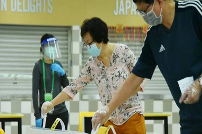 Cử tri Singapore đeo khẩu trang và găng tay bỏ phiếu tại Trường trung học Chung Cheng, ngày 10-7-2020. (Ảnh: Channel News Asia)