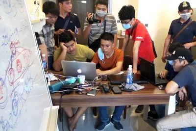 Lực lượng chức năng khám xét trụ sở của nhóm đối tượng điều hành sàn tiền ảo. Ảnh: MAI HOÀNG