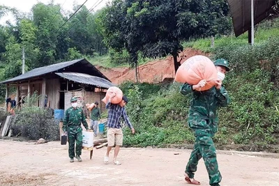 Bộ đội Biên phòng Na Mèo giúp người dân di chuyển khỏi khu vực sạt lở đất.