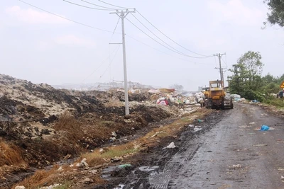 Các xe máy ủi rác lên cao tại bãi rác xã Tân Lập 1 (huyện Tân Phước).