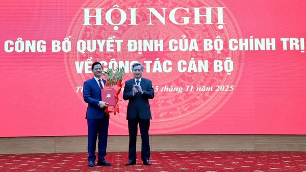 Đồng chí Nguyễn Quang Dương, Phó Trưởng ban Tổ chức Trung ương (bên phải) trao quyết định và tặng hoa chúc mừng đồng chí Vương Quốc Tuấn. (Ảnh: TUẤN SƠN)