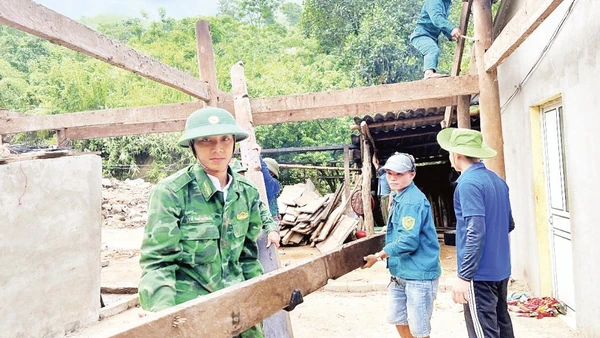 Cán bộ, chiến sĩ Đồn Biên phòng Nhôn Mai phối hợp các lực lượng di dời nhà dân bị ảnh hưởng do lũ quét.