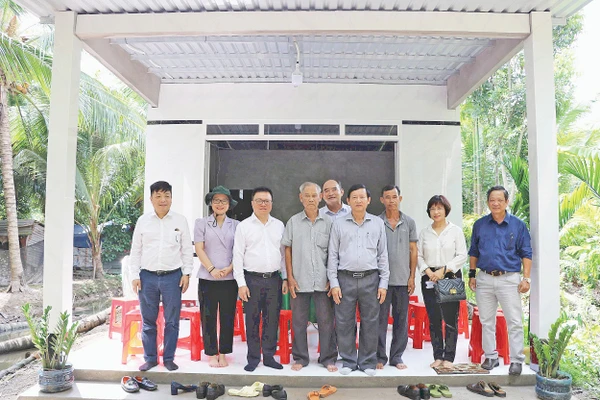 Lãnh đạo Báo Nhân Dân chụp ảnh lưu niệm trong một lần tặng quà hỗ trợ xây dựng nhà “Đại đoàn kết” khu vực Đồng bằng sông Cửu Long. Ảnh: BÁ DŨNG