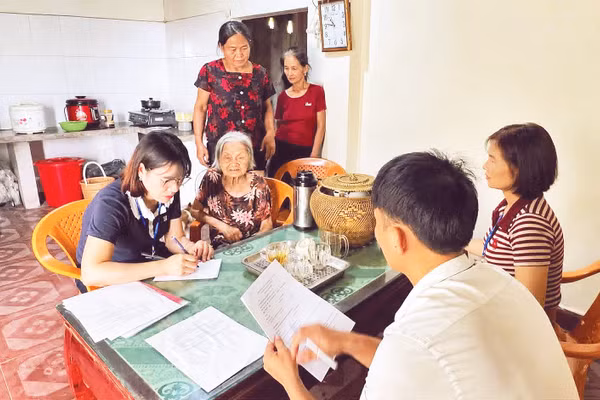 Cán bộ xã Đại Đồng đến tận nhà hỗ trợ người già yếu giải quyết thủ tục hành chính. Ảnh: Ngọc Anh
