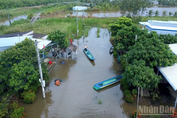 Một góc con đường gần 2km tại Kênh Tư ngập sâu, người dân phải dùng xuồng di chuyển trên mặt đường. 