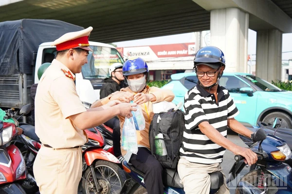 Cảnh sát giao thông Công an tỉnh Đồng Nai phát nước suối, khăn lạnh cho người dân trên Quốc lộ 1A.
