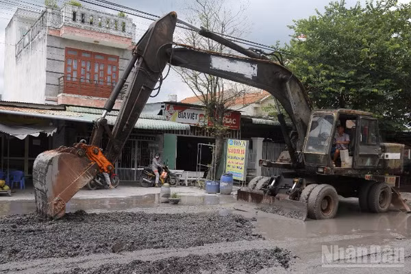 Đơn vị thi công dùng xe múc sửa chữa nền đường Bưng Môn.