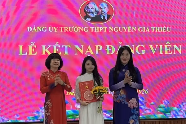 Bí thư Đảng ủy, Chủ tịch Hội đồng nhân dân phường Bồ Đề Vũ Thị Thành (người đứng bên trái) trao quyết định kết nạp Đảng cho học sinh trường Trung học phổ thông Nguyễn Gia Thiều.