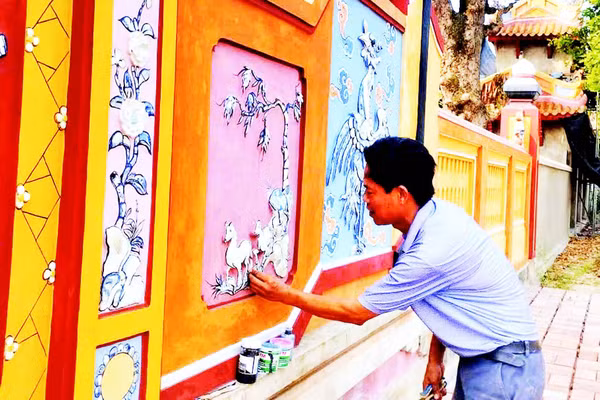 Nghệ nhân Đào Hữu Khiến thực hiện công đoạn khảm sành sứ trên bức bình phong tại Đại nội Huế.