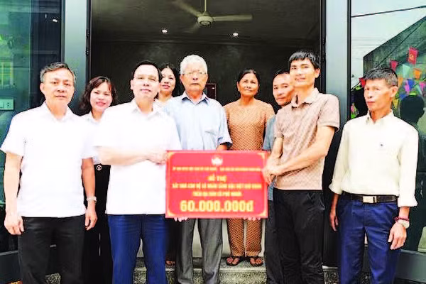 Bí thư Đảng ủy xã Phú Nghĩa Trịnh Tiến Tường (bên trái) trao biển hỗ trợ nhà ở cho hộ có hoàn cảnh khó khăn trên địa bàn.