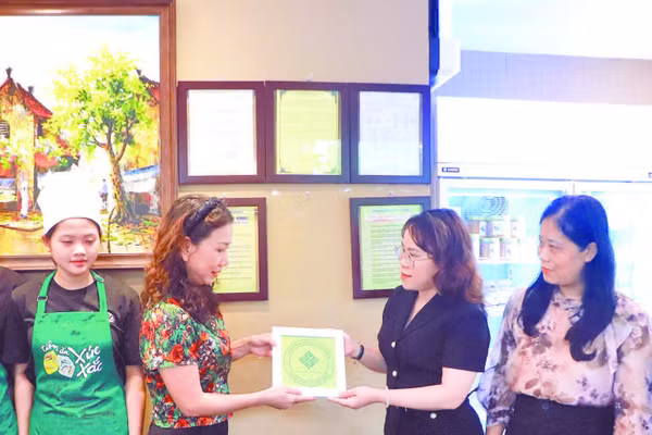 Đại diện UBND phường Cửa Nam trao Giấy chứng nhận đủ điều kiện an toàn thực phẩm cho cơ sở trên phố Quang Trung.