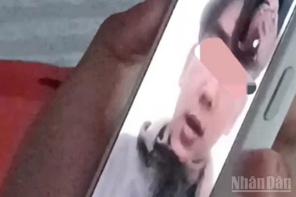 Ảnh cắt từ clip em T.D.H gọi điện thoại thông báo cho gia đình.