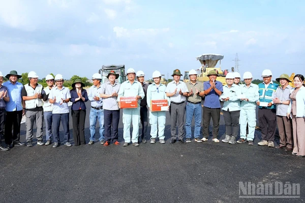 Bí thư Tỉnh ủy Nguyễn Hồ Hải và Chủ tịch Ủy ban nhân dân tỉnh Lữ Quang Ngời (cùng đội nón tai bèo có hình cờ Tổ quốc) tặng quà trên công trường cao tốc vào chiều 7/12.