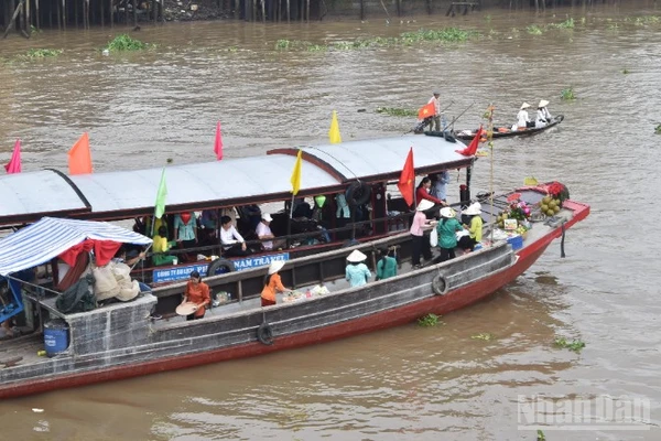 Tái hiện cảnh mua bán giữa thương lái và khách du lịch tại chợ nổi Cái Bè sáng 4/12/2025.