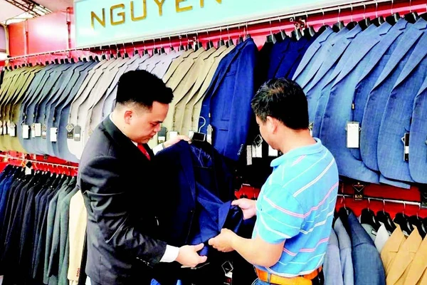 Cơ sở sản xuất Nguyễn Trung của làng nghề may Vân Từ giới thiệu sản phẩm tới khách hàng.